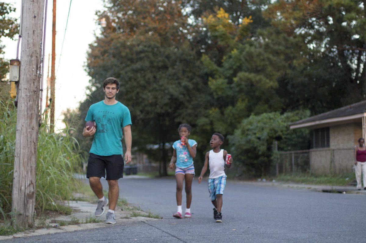 Pre-nursing sophomore Matthew Miller walks with a children on the way to Live 2 Serve's headquarters, the YMCA on Thomas H. Delpit Drive, on Sept. 27, 2017.