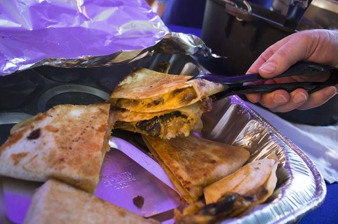 Krewe of Old School serve chicken and crawfish quesadillas at their tailgate on Saturday, Sept. 30, 2017, near Frey Computing Service Center.