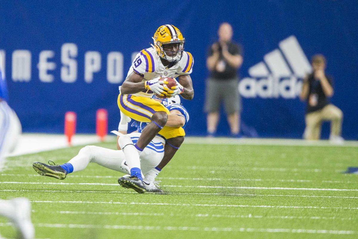 LSU sophomore wide-receiver Derrick Dillon (19) lands after successfully catching a pass from senior quarterback Danny Etling (16) during LSU's 27-0 win against BYU on Saturday, Sept. 2, 2017, at the Mercedes-Benz Superdome in New Orleans.