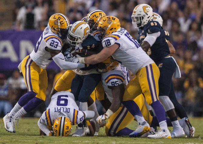 LSU football players tackle a player during LSU's 45-10 win against Chattanooga on Saturday, Sept. 9, 2017, at Tiger Stadium.