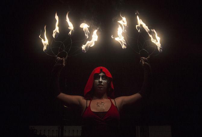 LSU anthropology sophomore Dixie Hinson performs with fire fans at Necropolis 13 on Monday, Oct. 9, 2017.