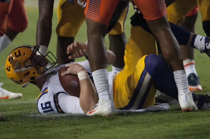 LSU senior quarterback Danny Etling (16) lies on the ground after a tackle during the Tigers' 35-26 win against Syracuse on Saturday, Sept. 23, 2017.