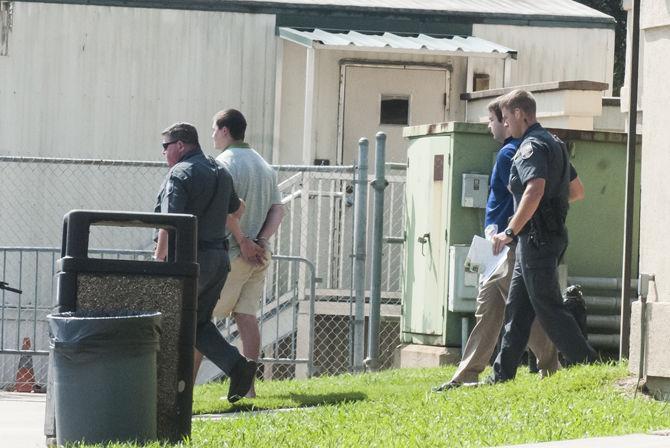 LSUPD escorts Patrick Forde (left) and university student Elliot Eaton (right) to the police cars after they turned themselves in following LSUPD issuing their arrest warrants on Wednesday, Oct. 11, 2017, at the LSU Public Safety Annex on LSU campus.