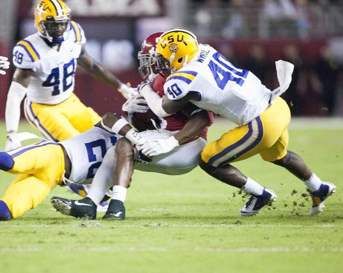 LSU junior safety John Battle (26) and sophomore linebacker Devin White (40) tackle Alabama junior running back Bo Scarbrough (9) during the Tigers' 10-24 loss to the University of Alabama on Saturday, Nov. 4, 2017, in Bryant&#8211;Denny Stadium in Tuscaloosa.