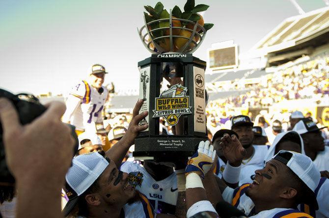 Several LSU team members raise their trophy on Saturday, Dec. 31, 2016, during the Tigers' 29-9 Buffalo Wild Wings Citrus Bowl win against Louisville at Camping World Stadium in Florida.