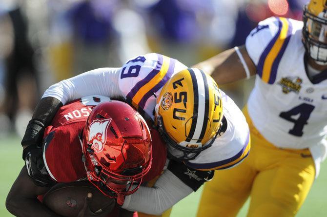 LSU sophomore linebacker Arden Key (49) takes down Louisville sophomore quarterback Lamar Jackson (8) on Saturday, Dec. 31, 2016, during the Buffalo Wild Wings Citrus Bowl in Orlando, Florida.