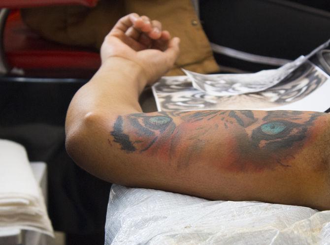 A customer remains still as the artist finishes his tattoo at Effum Underground's on Saturday, Jan. 20, 2018.