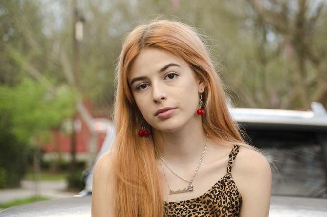 Isabella Dupre showcases her thrifted clothes on Friday, Feb. 23, 2018, outside her apartment on Spanish Town Road.