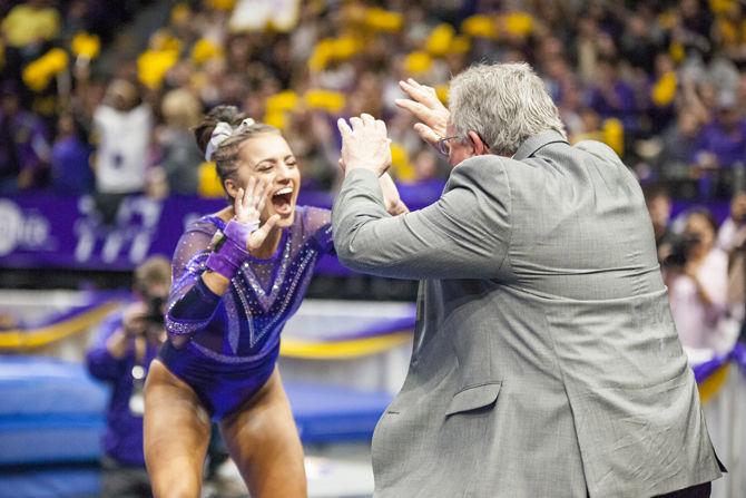 LSU junior Lexie Priessman celebrates with coach Bob Moore during the Tigers' 197.15-195.350 victory against Arkansas on Friday, Jan. 5, 2018, in the PMAC.