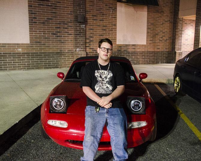 Dallas Johnson stands near his car at the LSU Auto Enthusiast Club meeting on Thursday, March 1, 2018, at the Wal-Mart parking lot on College Drive.