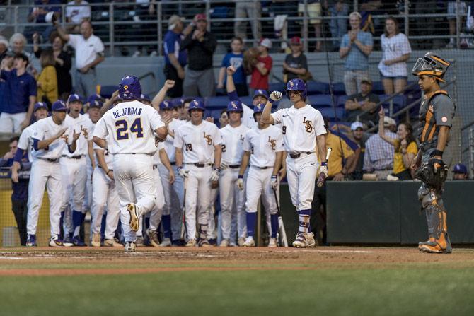 LSU senior outfielder Beau Jordan (24), greeted by his teammates, jogs into home plate after hitting a home run during LSU&#8217;s 9-3 victory over University of Tennessee in Alex Box Stadium on Friday, April 13, 2018.