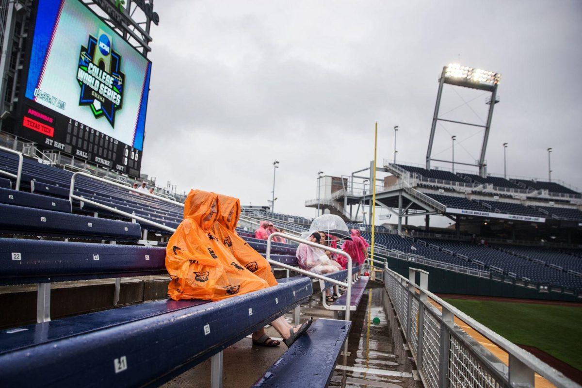 Sarah Steffensen, left, and Madeline Gorchels wait in the second row of the bleachers for the start of the Texas Tech and Arkansas game. The first row of the bleachers had several inches of standing water in it.&#160;