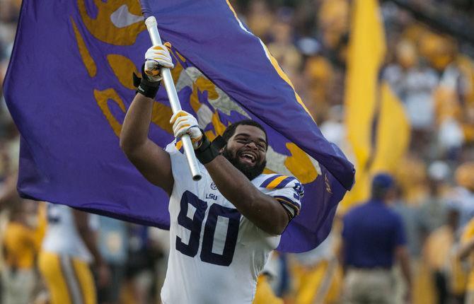 LSU sophomore defensive end Rashard Lawrence (90) runs with a flag during LSU's 27-23 victory against Auburn on Saturday, Oct. 14, 2017 at Tiger Stadium.