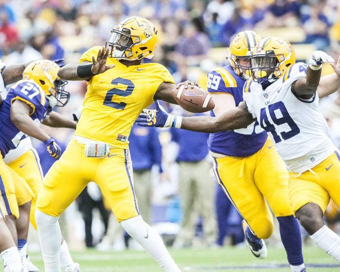 LSU freshman quarterback Lowell Narcisse (2) throws the ball while junior defensive end Travez Moore (49) defends during the purple team&#8217;s 28-27 victory against the gold team during the Spring Game on Saturday, April 21, 2018, at Tiger Stadium.