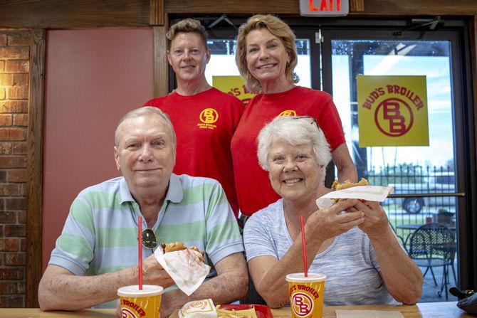 (top left to right) Business manager David Dillard and franchise owner Shannon McGuire visit with store regulars (bottom left to right) James and Rebecca Stanford as they enjoy a meal together at Bud&#8217;s Broiler on Friday, Aug. 17, 2018.