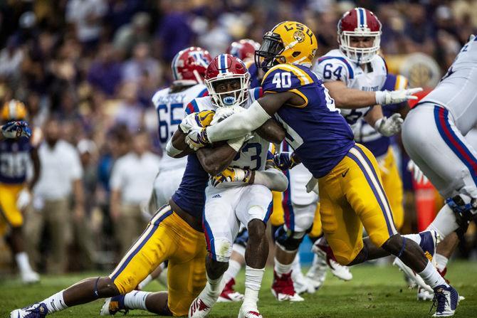 LSU sophomore linebacker Jacob Phillips (6) and LSU junior linebacker Devin White (40) tackle LA Tech's junior running back Jaqwis Dancy (23) during the Tigers' 38-21 win against LA Tech on Saturday, Sept. 22, 2018, at Tiger Stadium.