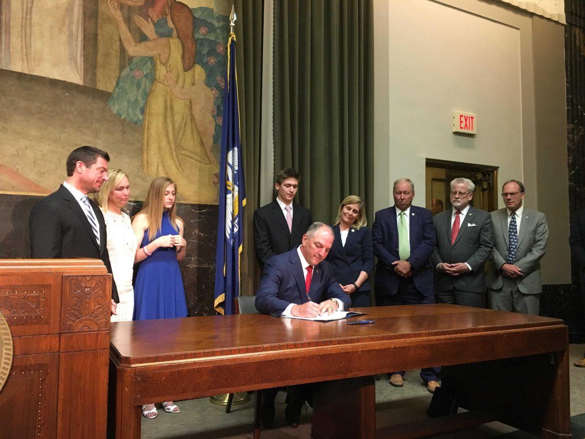 Gov. John Bel Edwards signs the Max Gruver Act among other anti-hazing legislation alongside the Gruver family on May 31 at the Louisiana State Capitol.&#160;