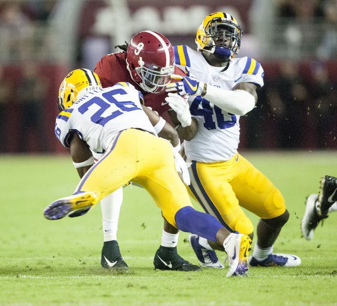 LSU junior safety John Battle (26) and sophomore linebacker Devin White (40) tackle Alabama junior running back Bo Scarbrough (9) during the Tigers' 10-24 loss to the University of Alabama on Saturday, Nov. 4, 2017, in Bryant&#8211;Denny Stadium in Tuscaloosa.