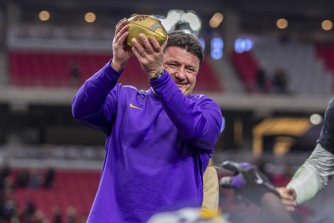 LSU coach Ed Orgeron holds the Fiesta Bowl trophy after the Tigers' 40-32 victory over UCF in State Farm Stadium on Tuesday, Jan. 1, 2019.