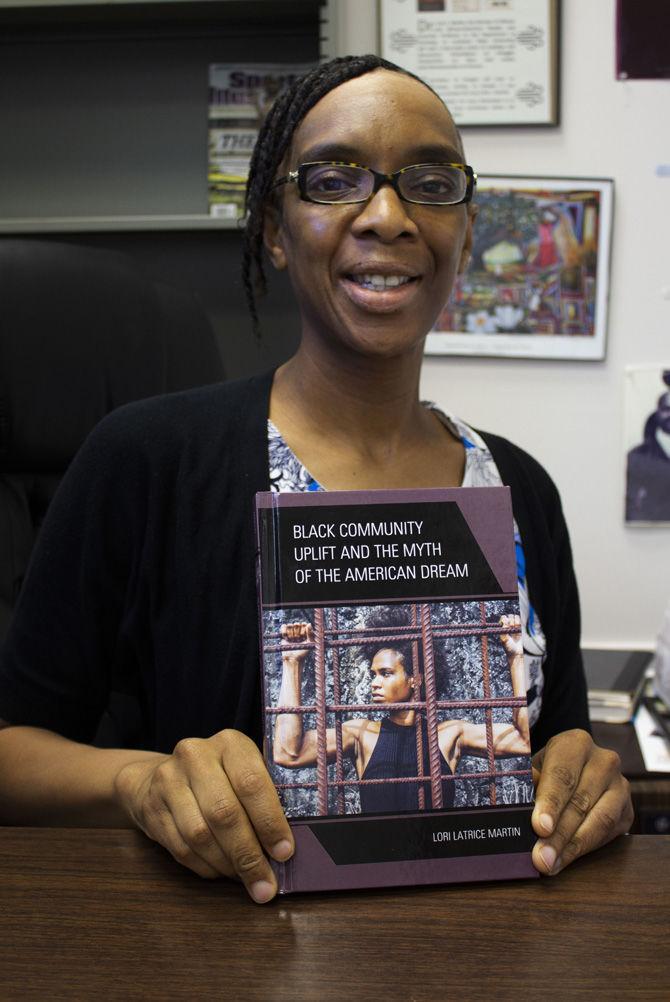 Dr. Lori Martin, Professor of Sociology and African American Studies, holds her new book "Black Community Uplift and the Myth of the American Dream," on Tuesday, March 19, 2019.