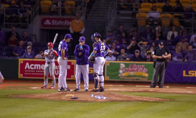 LSU baseball players converse with their coach during the Tigers' 5-3 victory over Lamar on Tuesday, April 23, 2019, in Alex Box Stadium.