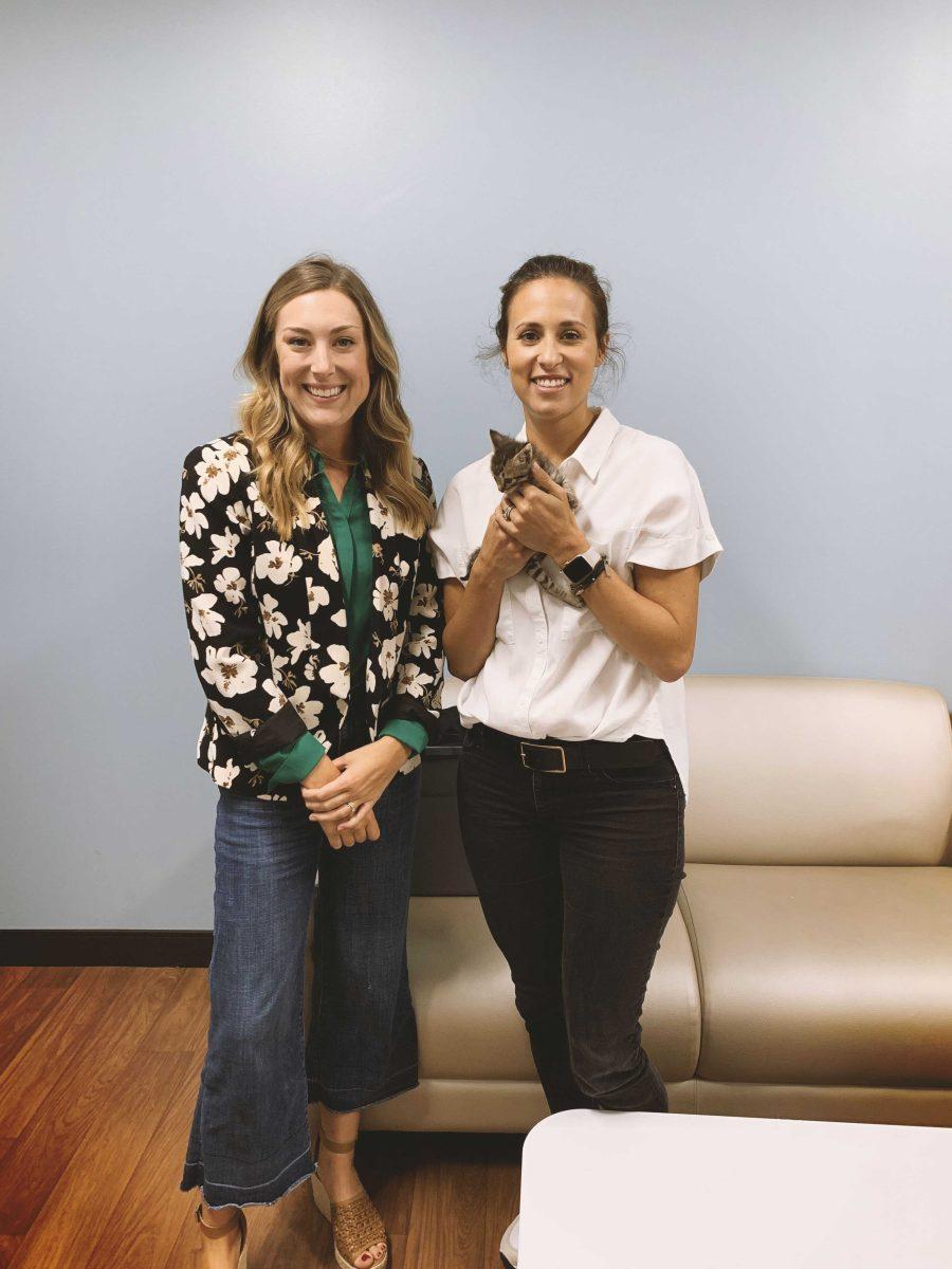 Emily Franklin and CAA Programs Director JT Hackett visit with animals at the Companion Animal Alliance shelter.