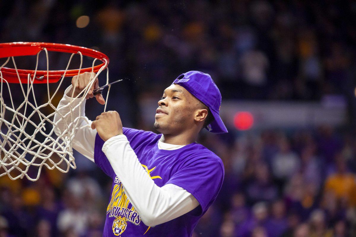 LSU freshman Ja'vonte Smart cuts the net after the Tigers' 80-59 victory over Vanderbilt on Saturday, March 9, 2019, in the PMAC.