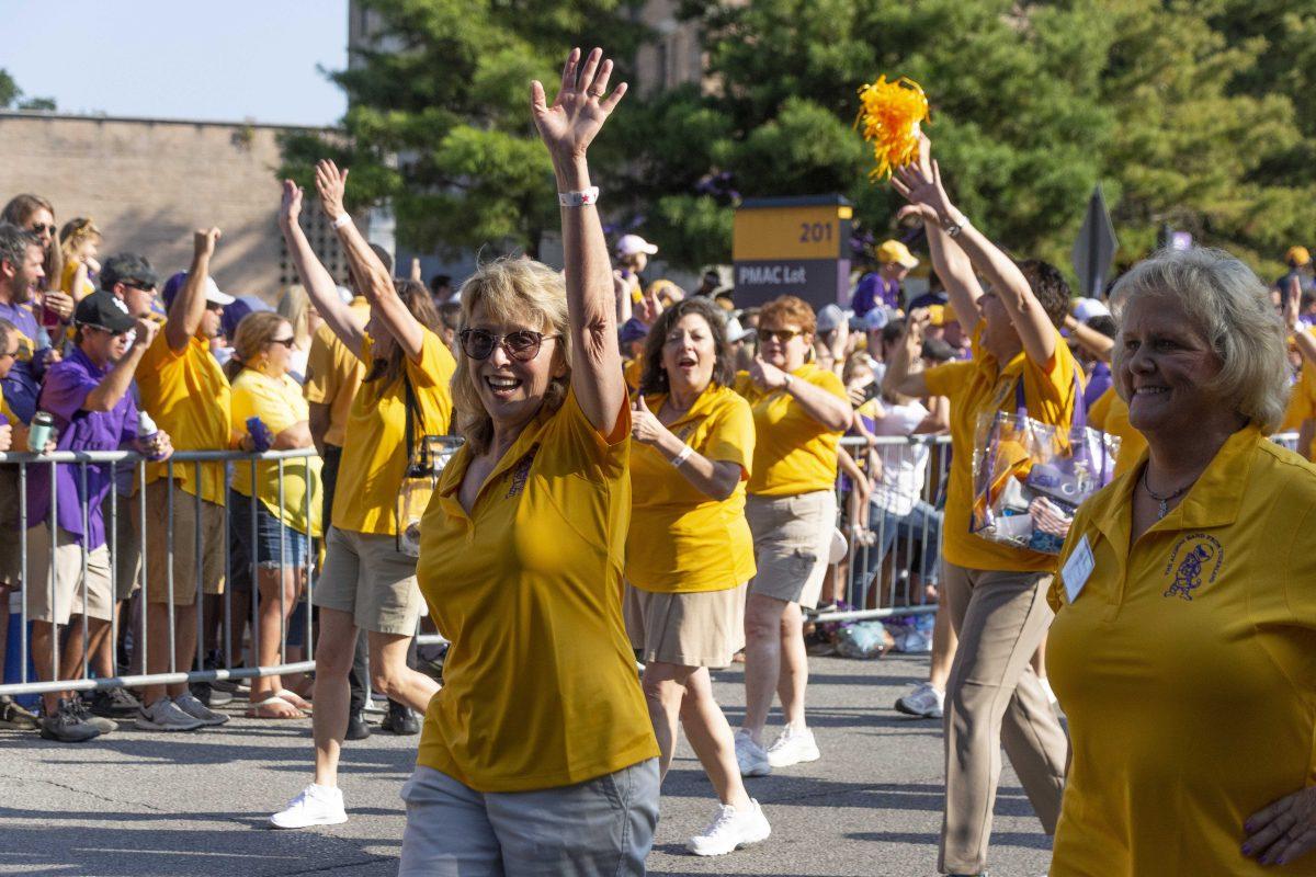 The LSU Alumni Band members waving at the crowd as they walk down Victory Hill on Saturday, October 5, 2019.