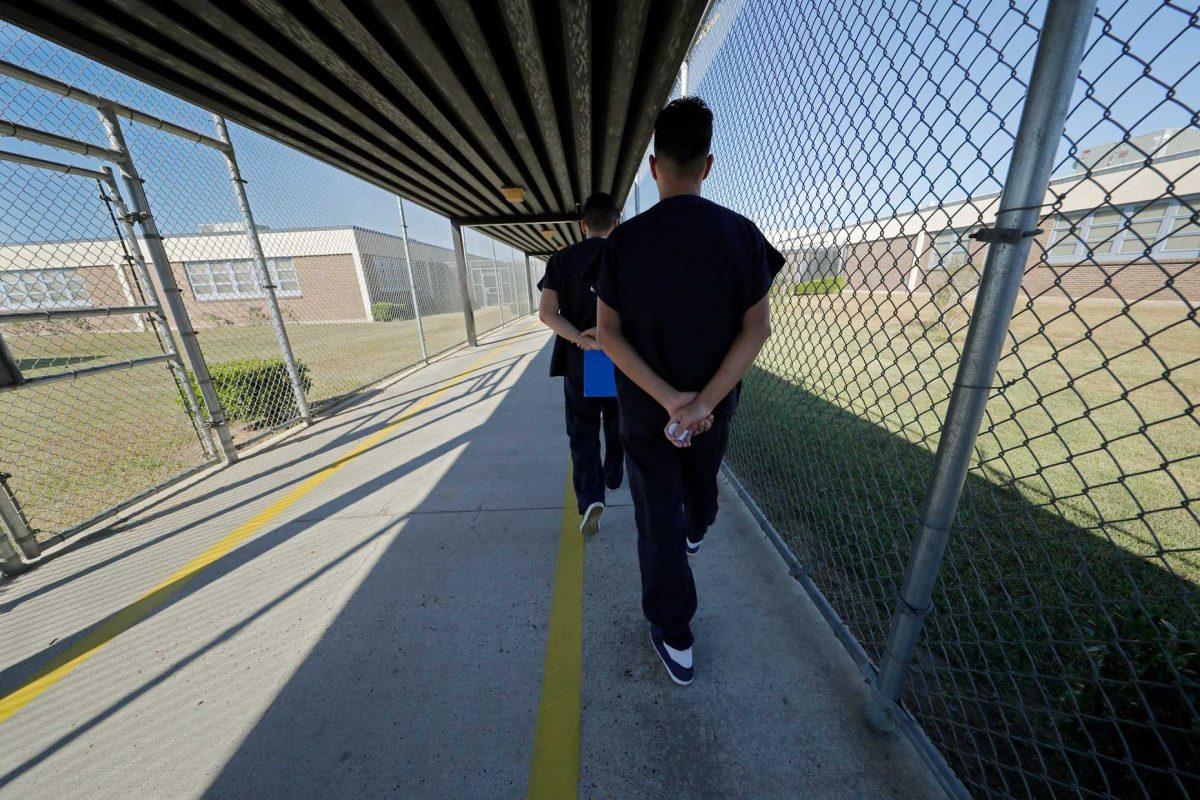 Detainees walk with their hands clasped behind their backs along a line painted on a walkway inside the Winn Correctional Center in Winnfield, La., Thursday, Sept. 26, 2019. Detainees are required to walk from site to site with their hands clasped behind their backs. Since 2018, eight Louisiana jails have started detaining asylum seekers, making Louisiana an unlikely epicenter for immigrant detention under President Donald Trump. Immigration and Customs Enforcement says it&#8217;s now detaining about 8,000 migrants in Louisiana out of 51,000 nationally. (AP Photo/Gerald Herbert)