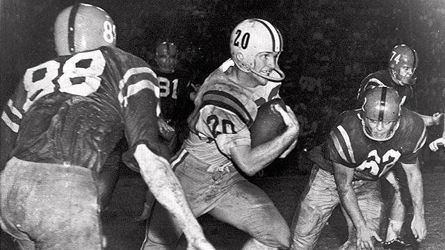 FILE - In this Oct. 31, 1959 file photo, Billy Cannon, Louisiana State University's All-America halfback, slips by tacklers at the start of an 89-yard punt return for a touchdown to help his champion Tigers beat third-ranked Mississippi, 7-3 in a college football game in Baton Rouge, La. On Saturday night, LSU will celebrate the half-century anniversary of Cannon's Halloween night punt return against Ole Miss, widely believed to be the play that clinched the Heisman Trophy for him. (AP Photo/File)