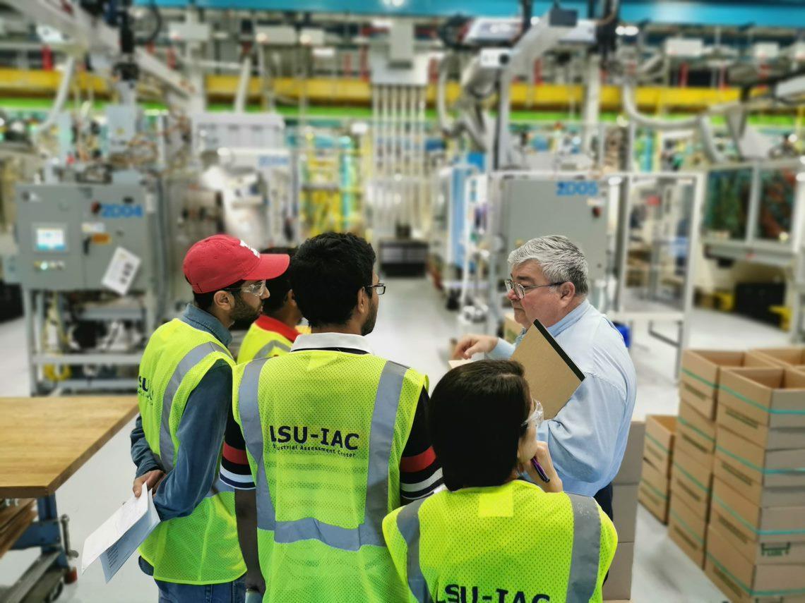 A group of LSU-IAC students consult with am employee from Intralox, a conveyor equipment manufacturer.