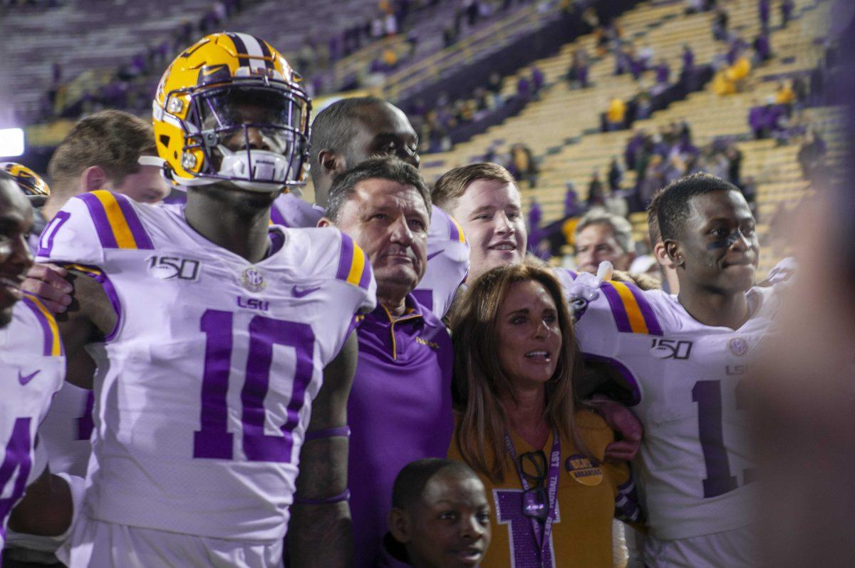 LSU head coach Ed Ogeron is surrounded by his players during the Alma Mater after the Tigers' victory over the Arkansas Razorbacks in Tiger Stadium on Saturday, Nov. 23, 2019.