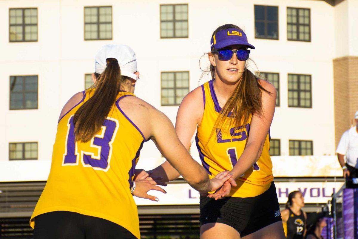 LSU junior, Kristen Nuss (13) and junior, Claire Coppola (14) celebrate during the Tigers' match against USM at the LSU Beach Volleyball Stadium on Saturday, March 23, 2019.