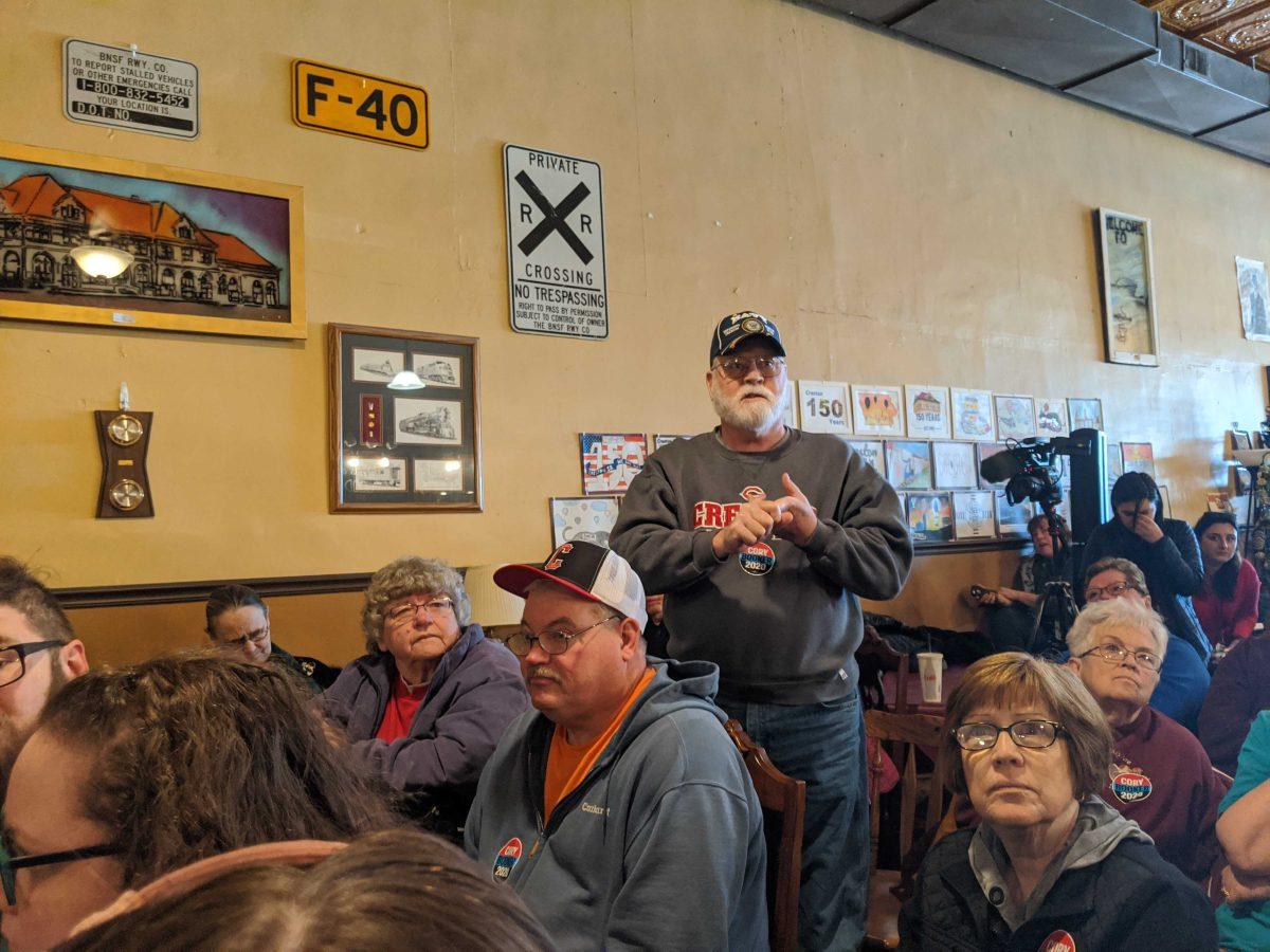 Tom Hawks, an Iowan retiree and navy veteran, stands up to ask a question to Cory Booker during his rally at Adam&#8217;s Street Espresso Cafe in Creston, Iowa on Jan. 1, 2020.