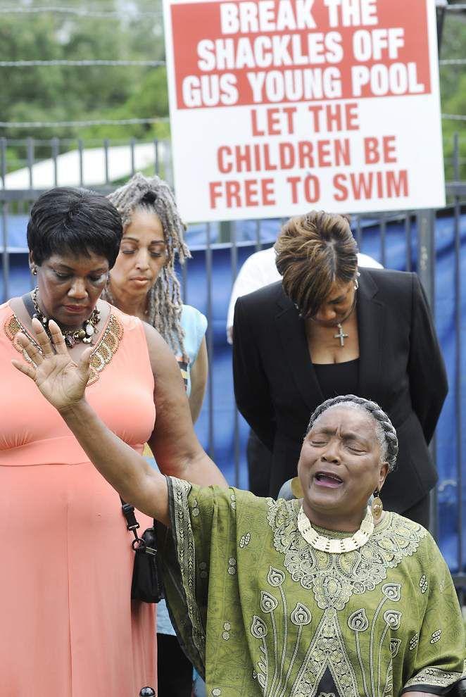 Rev. Betty Claiborne (seated) leads a prayer vigil with other community leaders at Gus Young Park swimming pool in response to the closing of the pool on June 16, 2015.