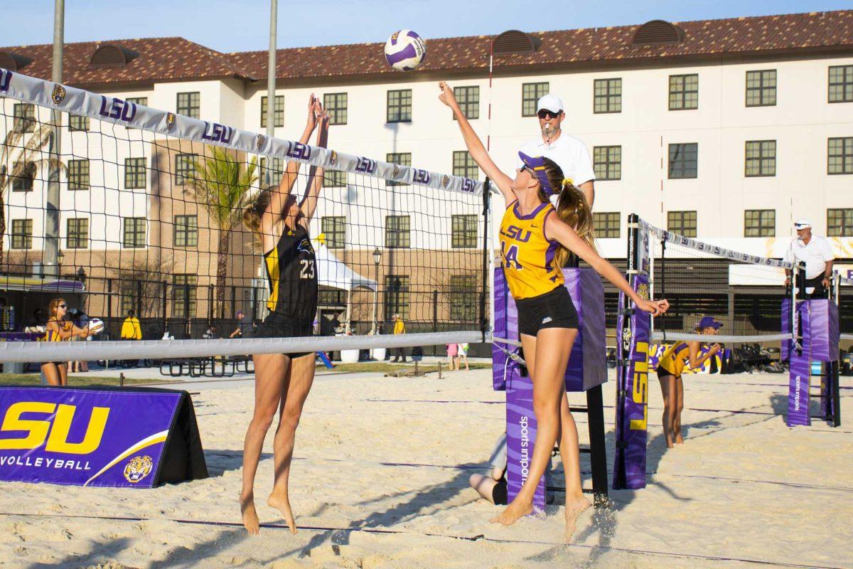 LSU junior, Claire Coppola (14) spikes the ball during the Tigers' match against USM at the LSU Beach Volleyball Stadium on Saturday, March 23, 2019.