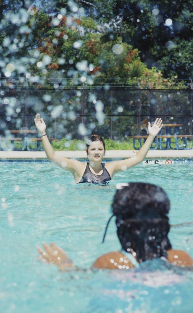 A Tank Proof volunteer teaches a child how to swim.