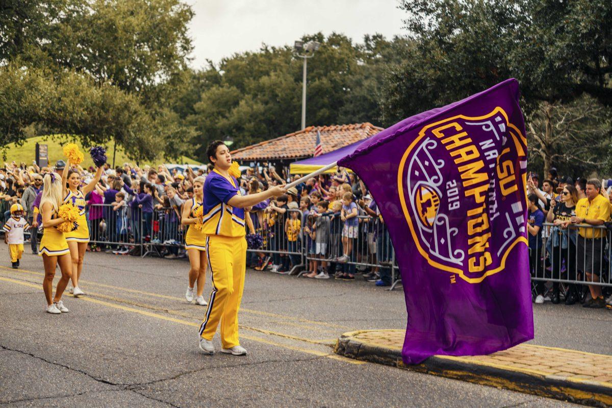 An LSU cheerleader waves the National Championship flag on Saturday, January 18, 2020 during LSU's National Championship Parade on Field House Drive.