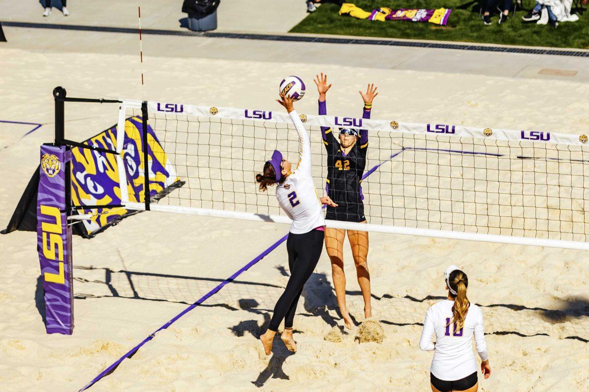 LSU beach volleyball sophomore Allison Coens (2) spikes the ball while senior Toni Rodriguez (42) blocks during the Purple vs. Gold scrimmage on Saturday, Feb. 15, 2020 at the Beach Volleyball Complex.