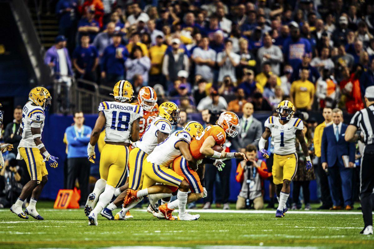 LSU football players tackle an opposing player on Monday, January 13, 2020 during LSU's 42-25 win against Clemson at the National Championship in the Mercedes-Benz Superdome.