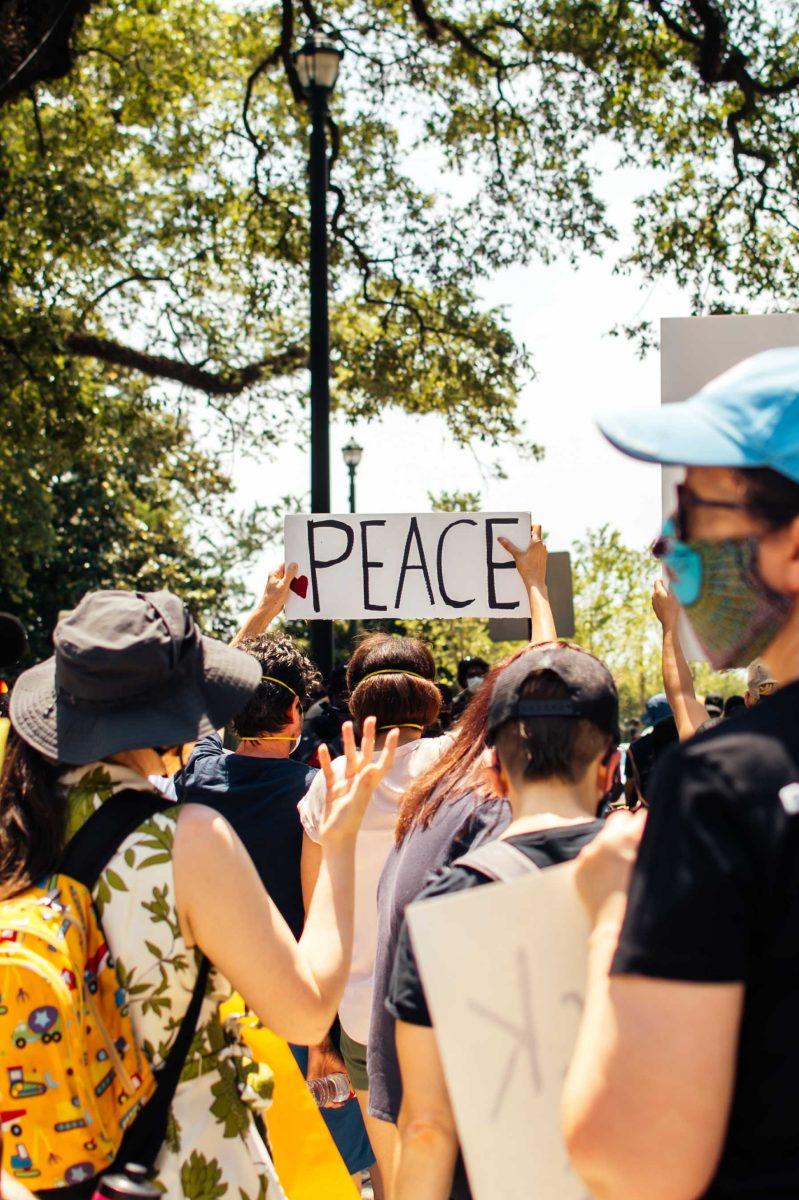 Protesters hold up a "peace" sign on Sunday, May 31, 2020 during the protest over George Floyd's death in Galvez Plaza in Downtown Baton Rouge.