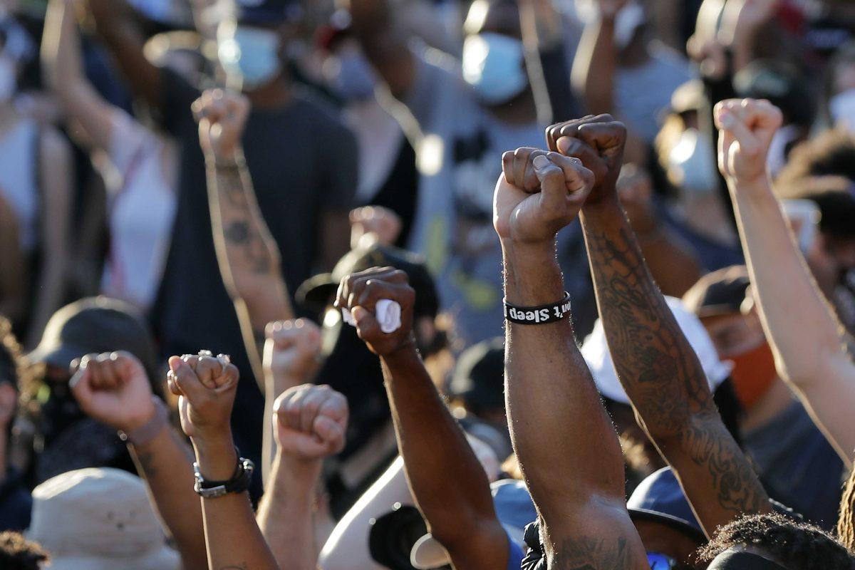 People raise their fists during a rally outside Jackson Square in New Orleans, Friday, June 5, 2020, protesting the death of George Floyd, a black man who was in police custody in Minneapolis. (AP Photo/Gerald Herbert)