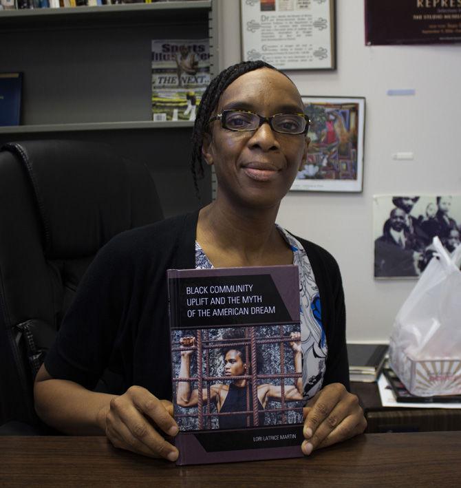 Dr. Lori Martin, Professor of Sociology and African American Studies, holds her new book "Black Community Uplift and the Myth of the American Dream," on Tuesday, March 19, 2019.