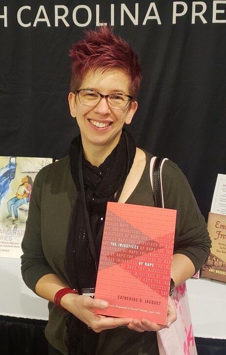 History professor Catherine Jacquet holds a copy of her book &#8220;The Injustices of Rape.&#8221;