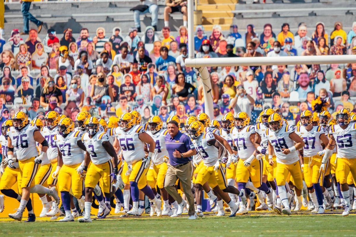 LSU football coach Ed Orgeron and the LSU football team run the field Saturday, Sep. 26, 2020 before LSU's 44-24 loss against Mississippi State in Tiger Stadium.