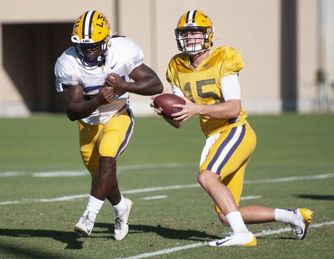 LSU sophomore quarterback Myles Brennan (15) passes the ball to&#160;freshman running back Chris Curry (24)&#160;at the Charles McClendon Practice Facility on Tuesday, Oct. 22, 2019.