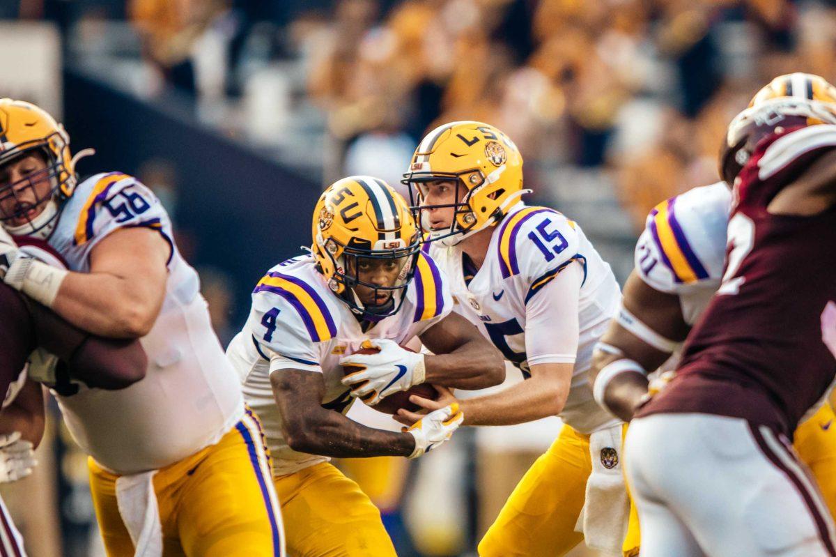 LSU football junior quarterback Myles Brennan (15) hands the ball off to sophomore running back John Emery Jr. (4) Saturday, Sep. 26, 2020 during LSU's 44-24 loss against Mississippi State in Tiger Stadium.