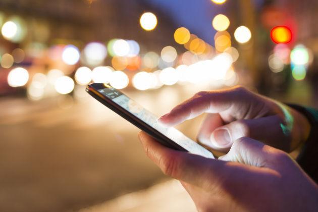 Man using his Mobile Phone in the street, bokeh