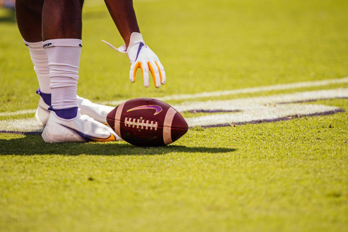 An LSU football player reaches for a football Saturday, Sep. 26, 2020 before LSU's 44-24 loss against Mississippi State in Tiger Stadium.