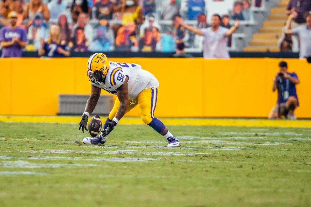 LSU football senior defensive end Neil Farrell Jr. (92) reaches down to catch the ball Saturday, Sep. 26, 2020 during LSU's 44-24 loss against Mississippi State in Tiger Stadium.